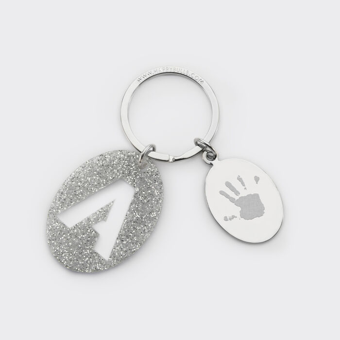 Porte-clés personnalisé médaille gravée ovale acier et breloque initiale acrylique pailleté argenté empreinte