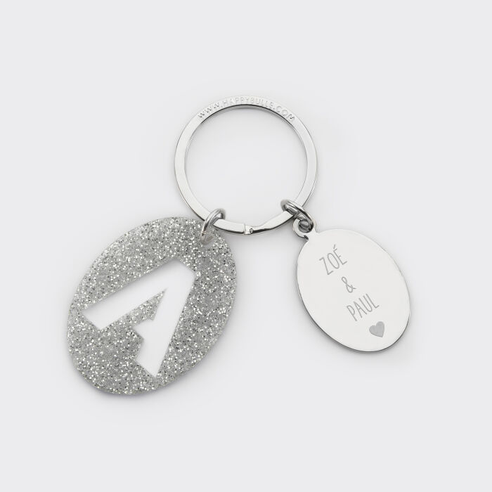 Porte-clés personnalisé médaille gravée ovale acier et breloque initiale acrylique pailleté argenté prénoms