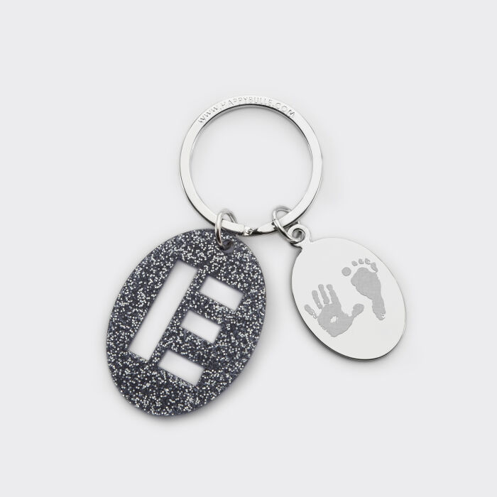 Porte-clés personnalisé médaille gravée ovale acier et breloque initiale acrylique pailleté bleu nuit empreintes