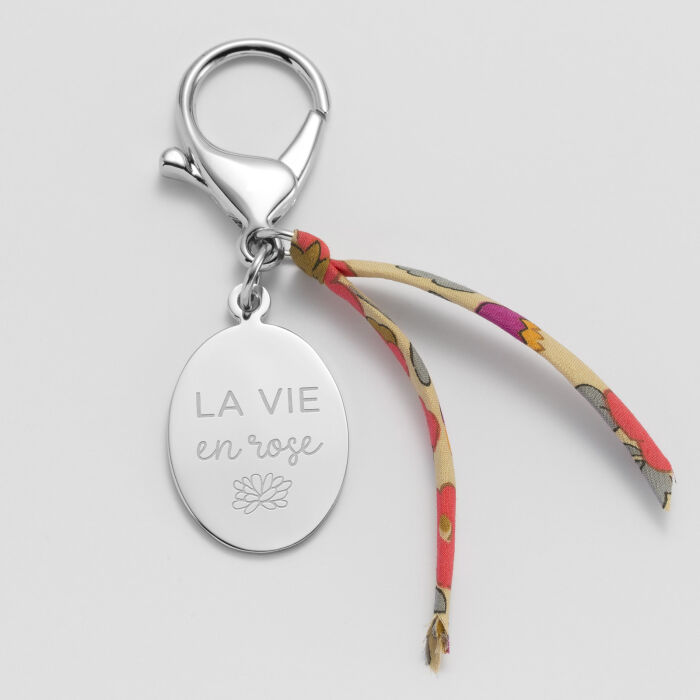 Bijou de sac personnalisé médaille gravée acier ovale 33x25 mm et noeud Liberty illustration